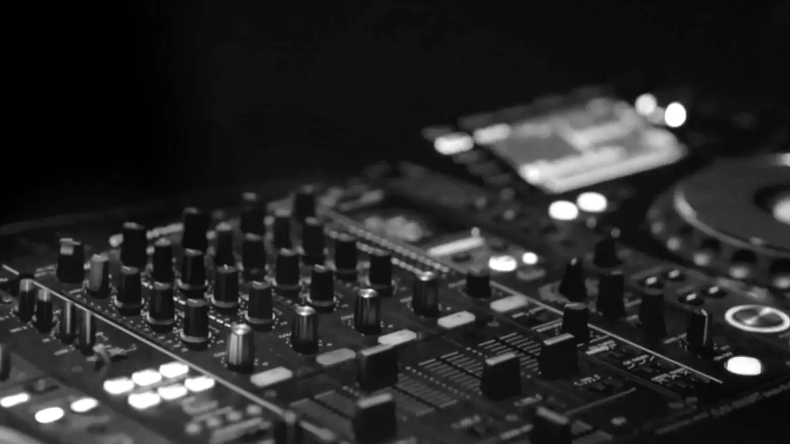 DJ-mixer med knapper og lysende display i mørket