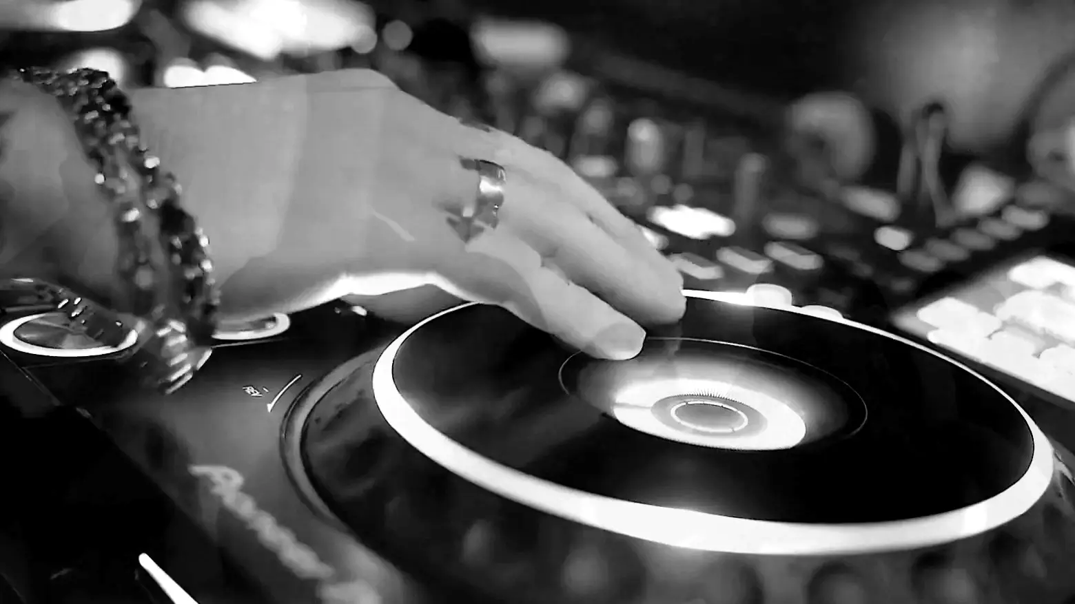 DJ’ens hånd på pladetallerkenen på en afspiller under et sæt